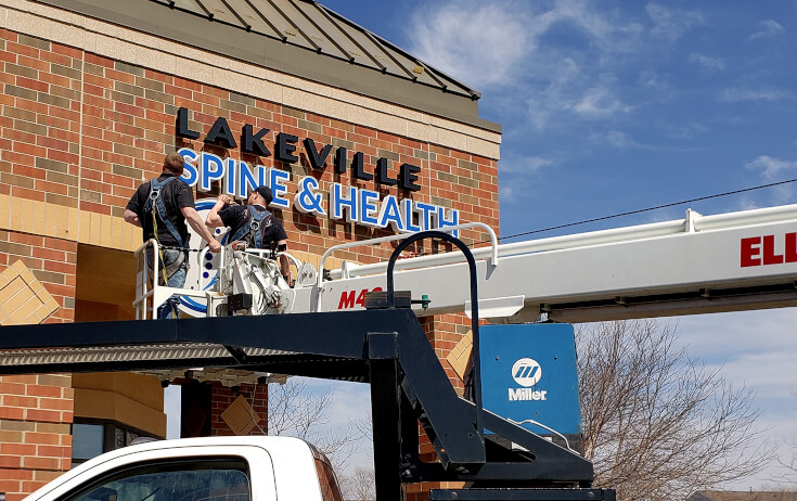 Installing Channel Letters on Storefront at Lakeville Spine and Health