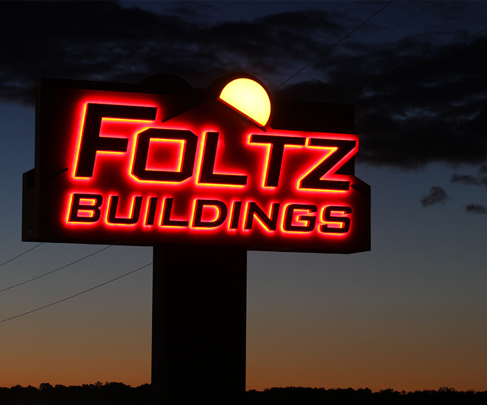 Foltz Buildings pylon sign lit at night Red halo lit channel letters moon in background detroit lakes mn