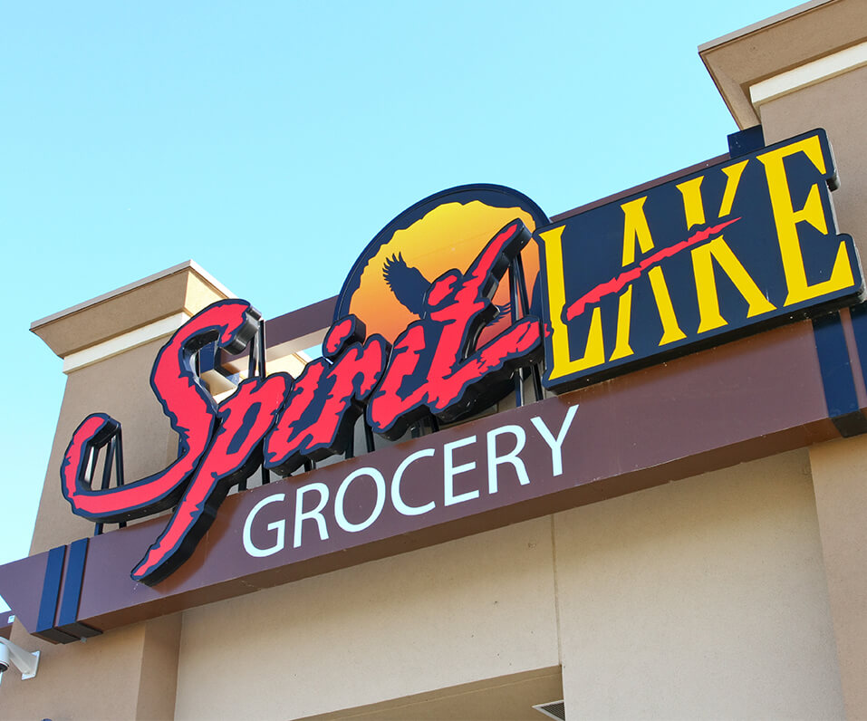 Spirit Lake Grocery custom shaped mounted channel letters on building with digitally printed logo cabinet layered in back